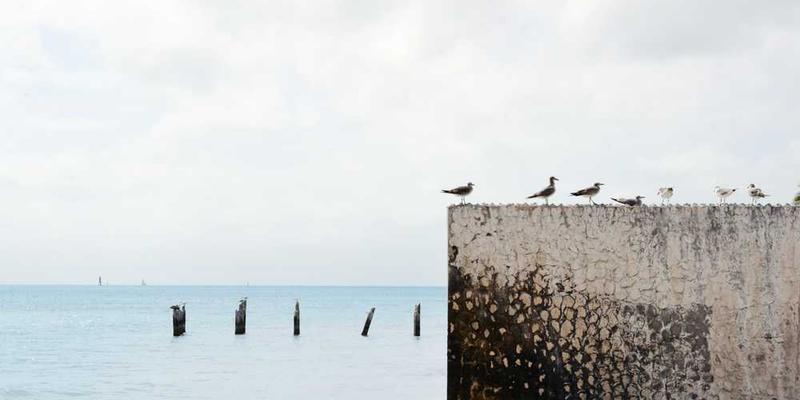 一把旧钥匙在阳光下闪耀，背景是忙碌的城市街道