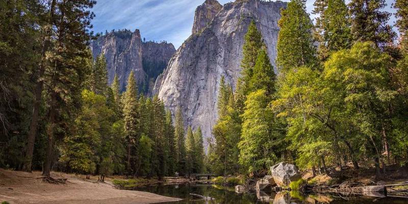 一位年轻人站在沙滩上，背后是落日余晖，手中拿着一本翻开的书籍，象征在有限的时间里，把握当下，追寻梦想。