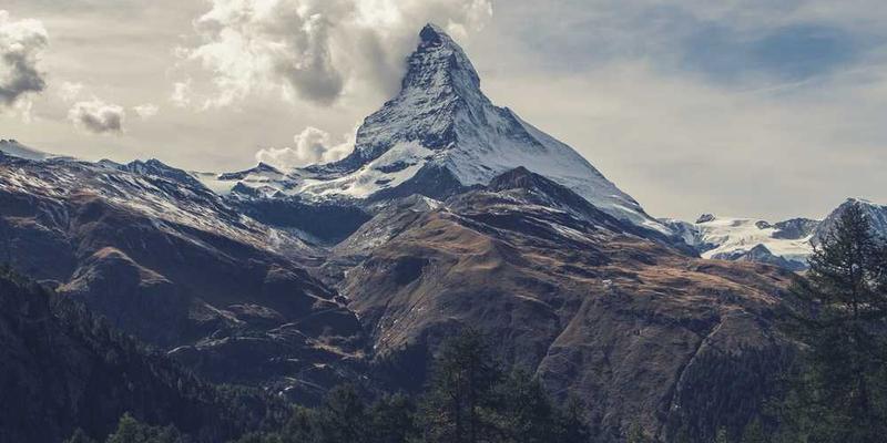 一位设计师坐在电脑前，周围散落着各种创意工具，背景是一个充满随机限制条件的界面，如颜色、形状、材质等
